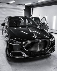 two black cars parked in a garage next to each other