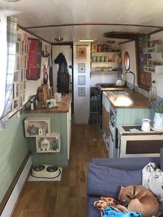 the interior of an rv with wood flooring and blue walls is shown in this image