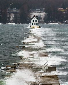 the waves are crashing against the pier and house