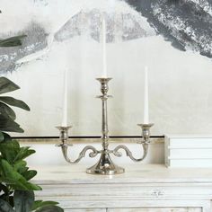 a silver candelabra sitting on top of a white table