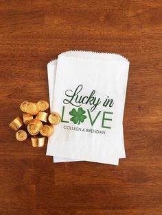 lucky in love paper bag with gold candy on wooden table next to small stack of chocolates