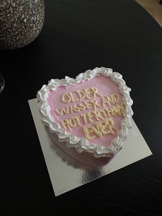 a pink heart shaped cake on top of a table