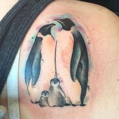 a woman with a penguin tattoo on her shoulder and two penguins in the background, all facing each other