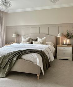 a bedroom with a large bed and two lamps on either side of the headboard