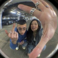 a man and woman taking a selfie in front of a mirror with their fingers up