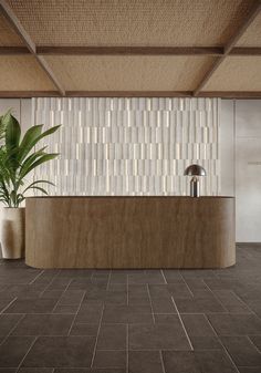 an office lobby with tiled walls and flooring is pictured in this image, there are two planters on the counter