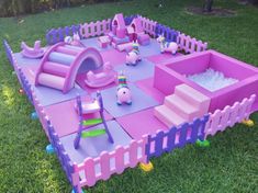 an inflatable play area with toys on the ground and some grass around it