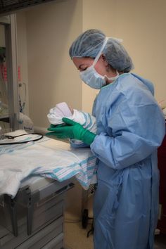 two doctors in scrubs and masks are performing surgery