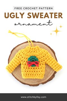 Yellow Christmas sweater ornament adorned with a green wreath with red bow. Crochet Ugly Christmas Sweater Ornament Pattern, Crochet Christmas Sweater Ornament Pattern, Christmas Crafts To Crochet, Mini Crochet Ornaments Patterns, Crochet Ugly Sweater Ornaments, Crochet Ugly Christmas Sweater Ornament Free Pattern, Ugly Christmas Sweater Crochet Pattern Free, Sweater Ornament Crochet, Crochet Sweater Ornaments Free Pattern