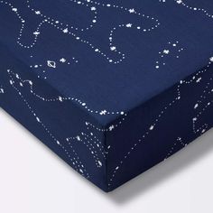 a blue bed sheet with white stars and swirls printed on it, laying flat