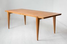 a wooden table sitting on top of a white floor