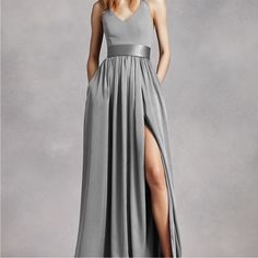 a woman wearing a long gray dress with a slit