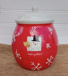 a red ceramic pot with a snowman on it