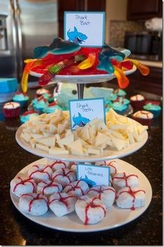 three tiered trays filled with different types of food on top of a table