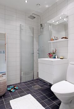 a white bathroom with tiled floor and walls