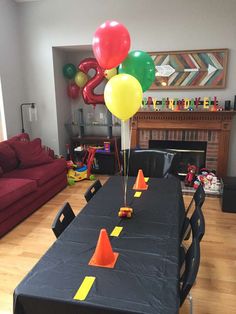 a party table with balloons and cones on it