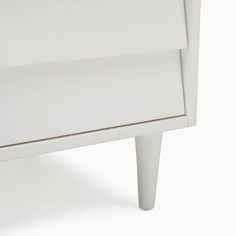 a white nightstand with two drawers on one side and an open drawer on the other