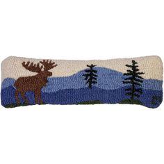 a pillow with a moose and trees on it