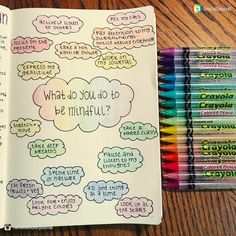 an open notebook with colored crayons next to it on a wooden table, which is filled with what do you need to be mindful?