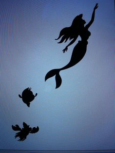 the silhouettes of two mermaids and a fish are shown against a blue background