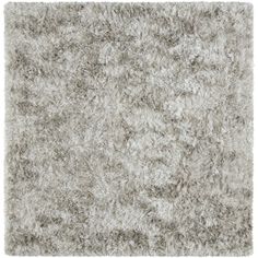 an area rug with grey and white shaggys on the top, in front of a white