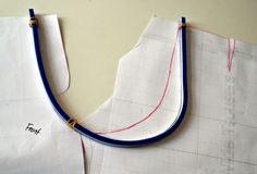 two pieces of white paper with blue and red thread on them