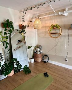 a yoga mat, mirror and potted plants in a room