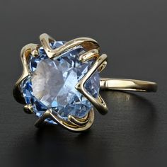 This Vintage Anniversary Ring Is Made Of 10 Karat Yellow Gold And Features A Large Round-Cut Blue Topaz Gemstone In A Unique Prong Setting. The Band Is A Size 6.5 (Is Resizable By Any Reputable Jeweler) & Has "Lido" / "10k" Stamped Onto The Inner Part Of It. Produced By Lido Jewelers. Size: 6.5 (Resizable) Metal: 10 Karat Yellow Gold Stones: Round Swiss Blue Topaz (12mm) Weight: 3.76dwt / 5.85g I-3227* E-1133 Vintage Anniversary Rings, Vintage Anniversary, Yellow Gold Solitaire, Blue Topaz Gemstone, Swiss Blue Topaz, Topaz Gemstone, Anniversary Ring, Womens Jewelry Rings, Anniversary Rings