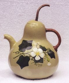 a ceramic tea pot with flowers painted on it