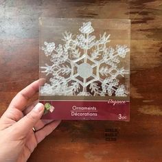 someone is holding up a clear box with snowflakes on it