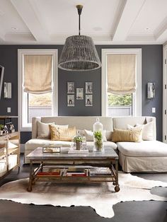 a living room filled with furniture and windows covered in shades of gray, yellow and white