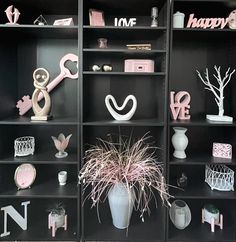 the shelves are decorated with pink and white decorations, such as keys, flowers, vases and other decorative items