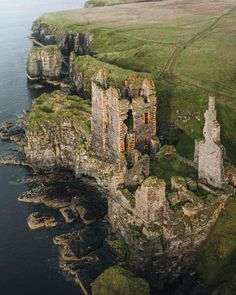 an aerial view of castle ruins on the coast