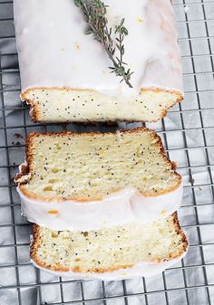 a loaf of lemon poppy seed bread on a cooling rack with two slices cut off