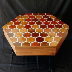 a small wooden box sitting on top of a black table with white and red designs