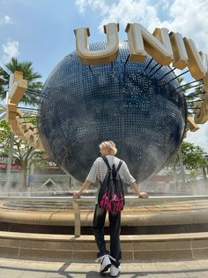 a person standing in front of a fountain with the word luna on it's side