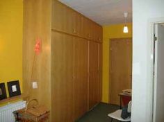 an empty room with yellow walls and wooden closets