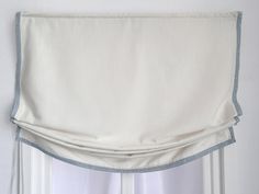 a white curtain hanging on the side of a window