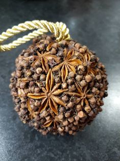 an ornament made out of pine cones and nuts on a table with rope