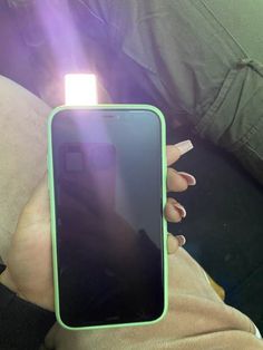 a person holding up a cell phone in their hand with the light shining on them