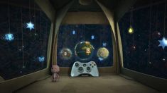 a video game controller sitting in front of a window with stars on the wall and a stuffed animal next to it