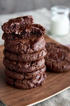 chocolate cookies stacked on top of each other with a glass of milk in the background