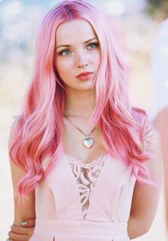 a woman with pink hair is posing for the camera