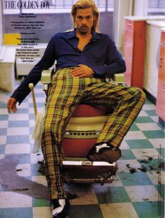 a man sitting on top of a chair wearing plaid pants