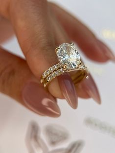 a close up of a person's hand holding a diamond ring