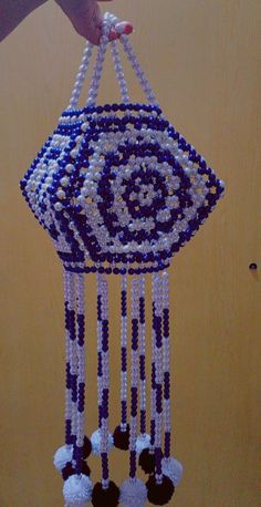 a hand is holding a beaded hanging decoration