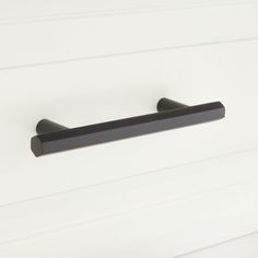 a black door handle on a white wall