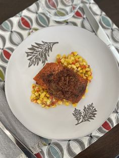 a white plate topped with corn and meat