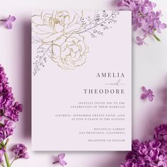 the wedding card is surrounded by purple flowers and greenery on a light pink background