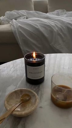 a candle sitting on top of a table next to a plate with ice cubes